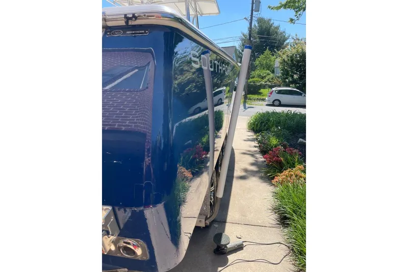 Slide: The Image of 2005 Southport 28 Center Console boat, blue hull, parked on driveway with garden view. - 7