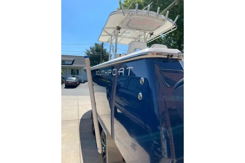 Slide: The Image of 2005 Southport 28 Center Console boat with blue hull, parked in driveway. - 8