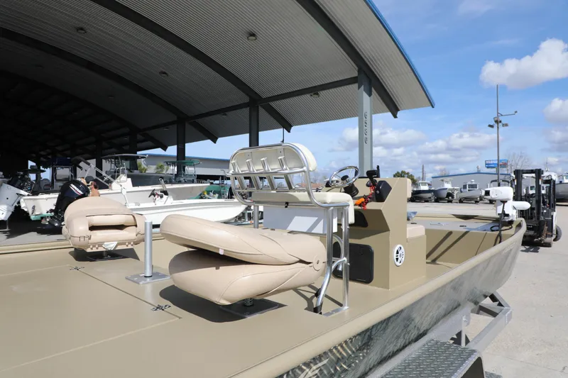 Slide: The Image of 2025 Xtreme 2072 boat with beige seating under a metal canopy at a marina. - 7