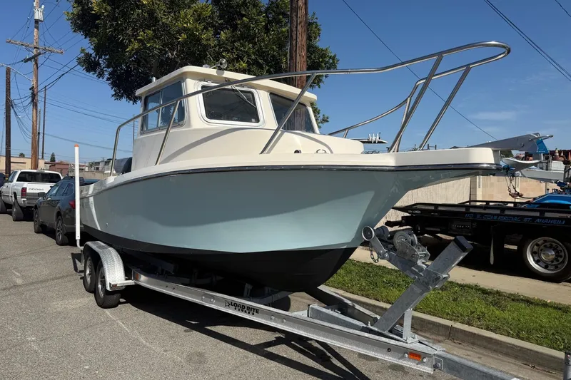 The Image of 2021 Defiance Admiral 220 EX boat on trailer, parked on street. - 1