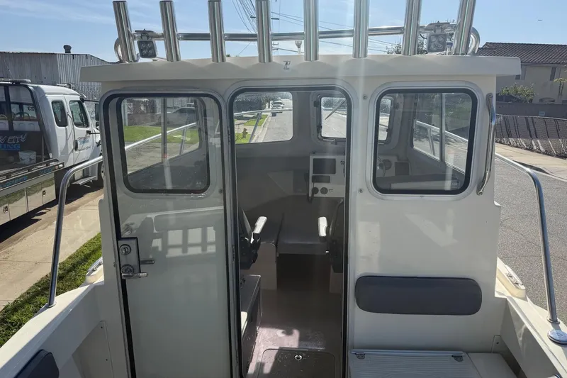 Slide: The Image of 2021 Defiance Admiral 220 EX boat interior with helm and seating. - 10