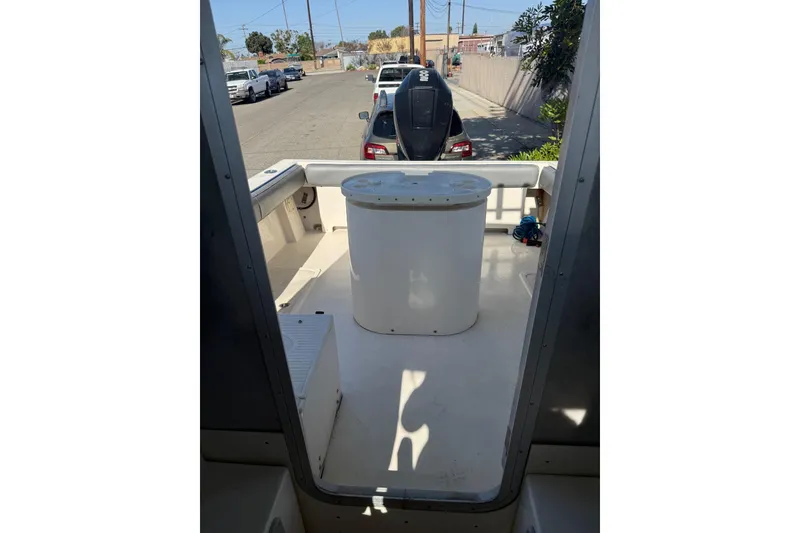 Slide: The Image of 2021 Defiance Admiral 220 EX boat interior with seating and storage, parked on a street. - 16