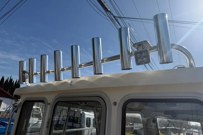 Slide: The Image of Rod holders on a 2021 Defiance Admiral 220 EX boat under a clear blue sky. - 20