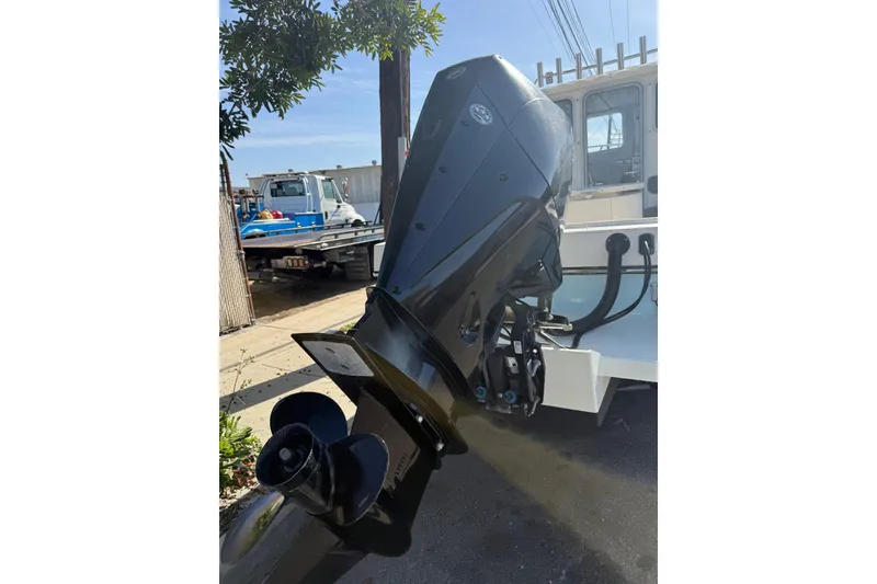 Slide: The Image of 2021 Defiance Admiral 220 EX boat with powerful outboard motor in a sunny outdoor setting. - 23