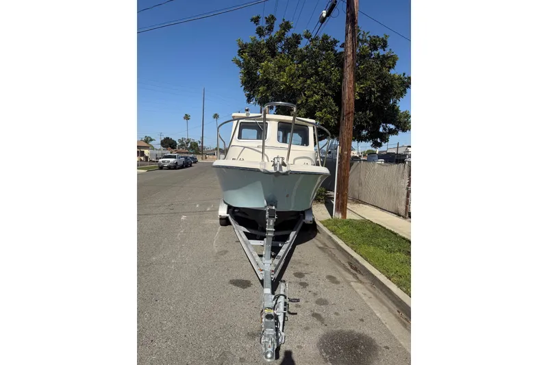 Slide: The Image of 2021 Defiance Admiral 220 EX boat on trailer, parked on a suburban street. - 5