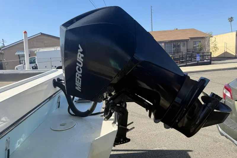 Slide: The Image of Mercury outboard motor on 2021 Defiance Admiral 220 EX boat, parked in urban setting. - 6
