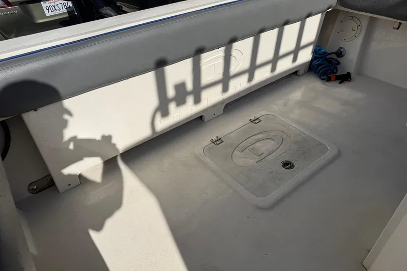 Slide: The Image of 2021 Defiance Admiral 220 EX boat interior with storage hatch and coiled rope. - 8