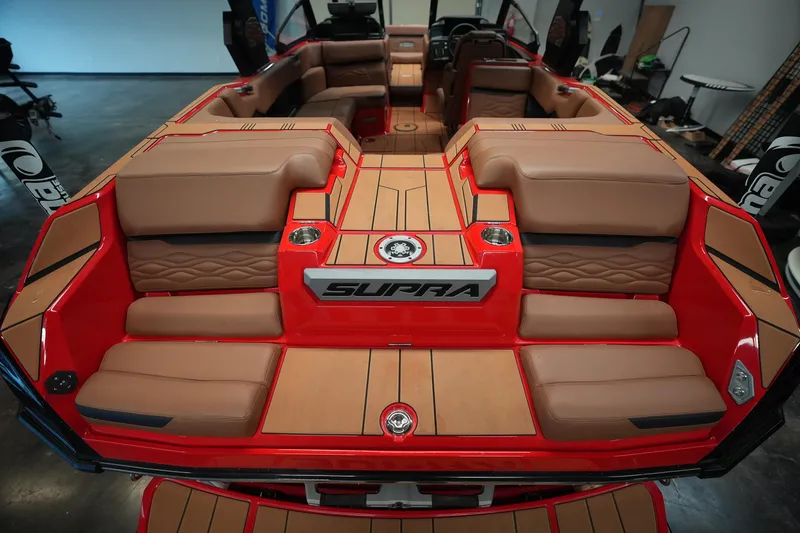Slide: The Image of 2026 Supra SA boat interior with luxurious tan seating and red accents. - 10