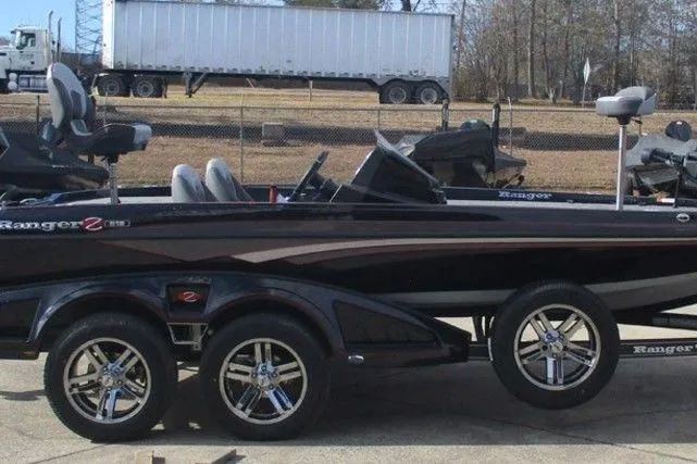 Slide: The Image of 2026 Ranger Z518 Cup-Equipped boat on trailer, sleek design, dual axles, parked outdoors. - 7