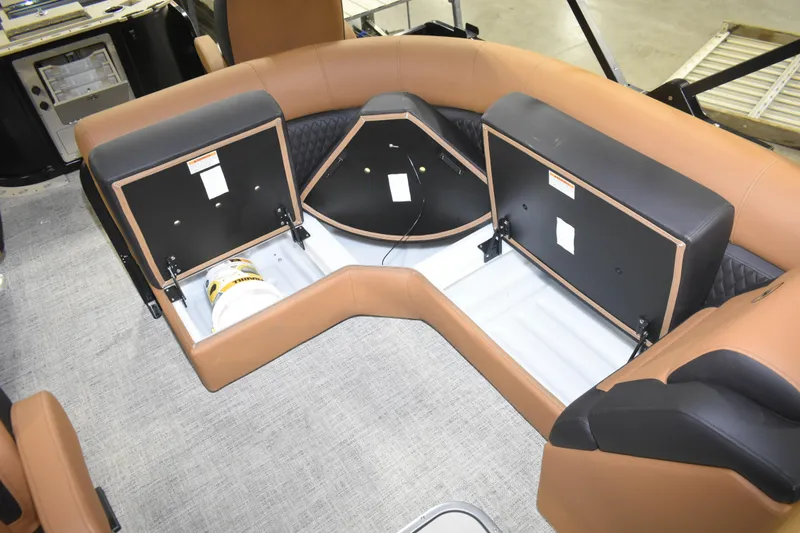 Slide: The Image of Interior storage compartments of 2026 Premier 230 Angler 2 Point boat, featuring tan seating. - 12