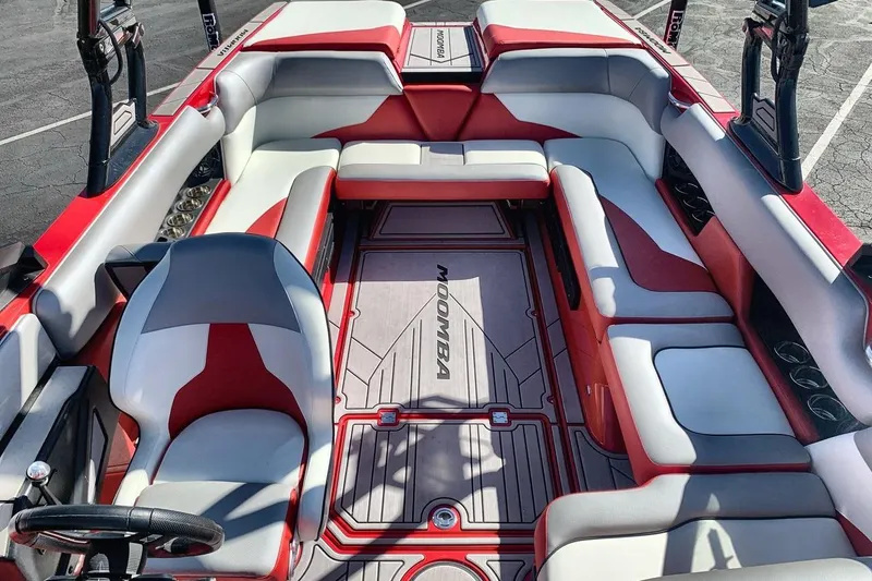 Slide: The Image of 2023 Moomba Mojo boat interior with red and gray seating, spacious layout, and modern design. - 12