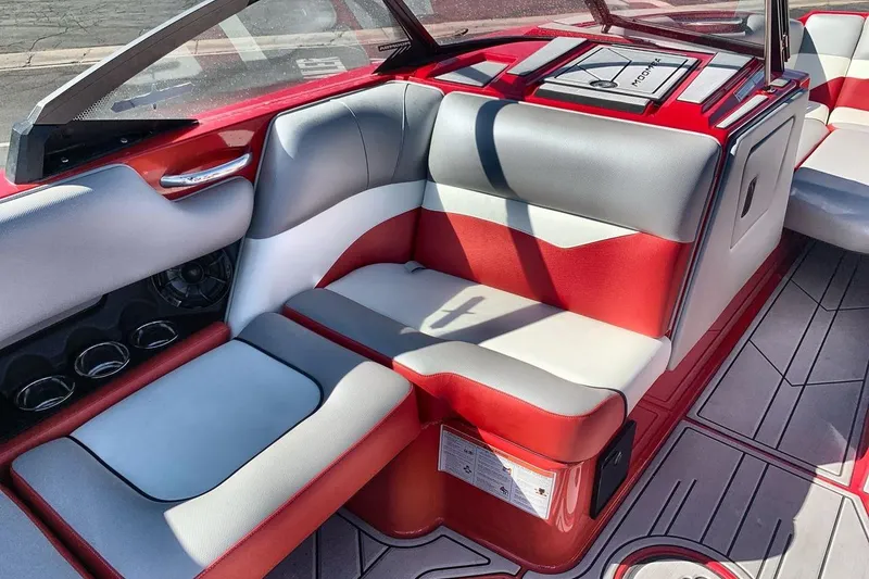 Slide: The Image of 2023 Moomba Mojo boat interior with red and gray seating, cup holders, and sleek design. - 17