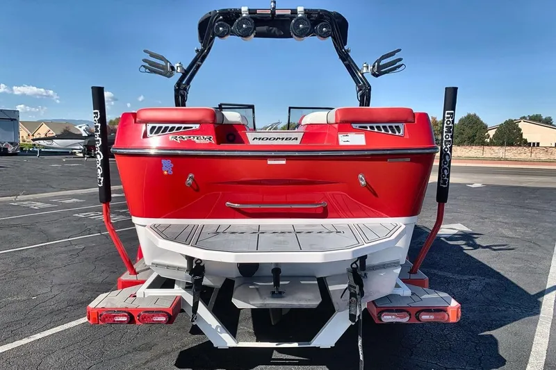 Slide: The Image of 2023 Moomba Mojo boat, red exterior, parked in a lot, rear view. - 4