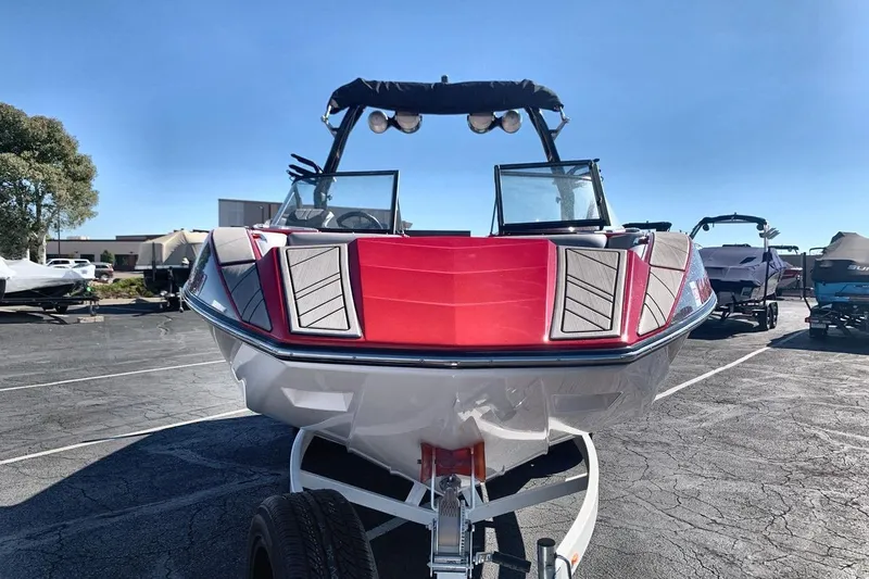 Slide: The Image of 2023 Moomba Mojo boat with red and gray accents on a trailer in a parking lot. - 8