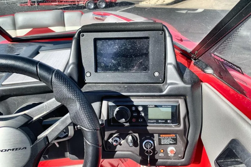 Slide: The Image of 2023 Moomba Mojo boat dashboard with steering wheel and control panel. - 16