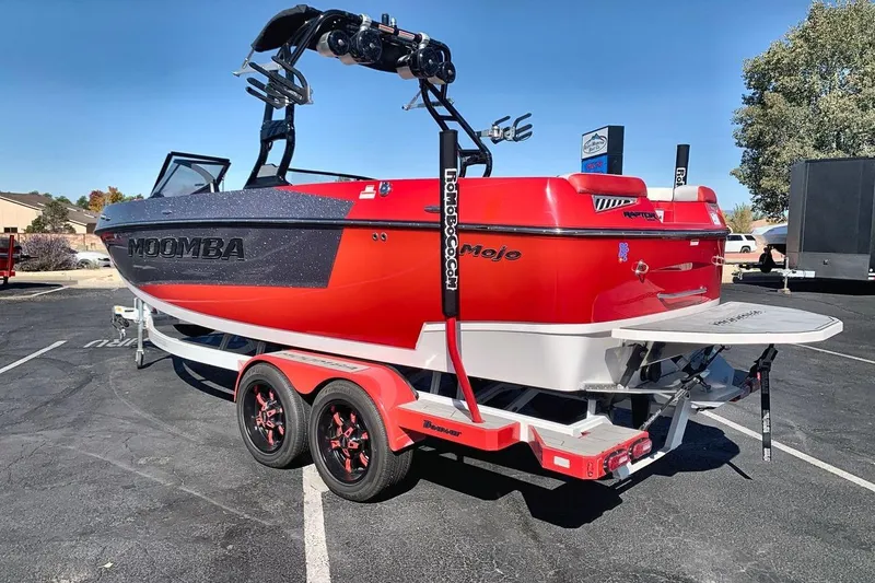Slide: The Image of 2023 Moomba Mojo boat in vibrant red on a trailer, parked outdoors. - 3