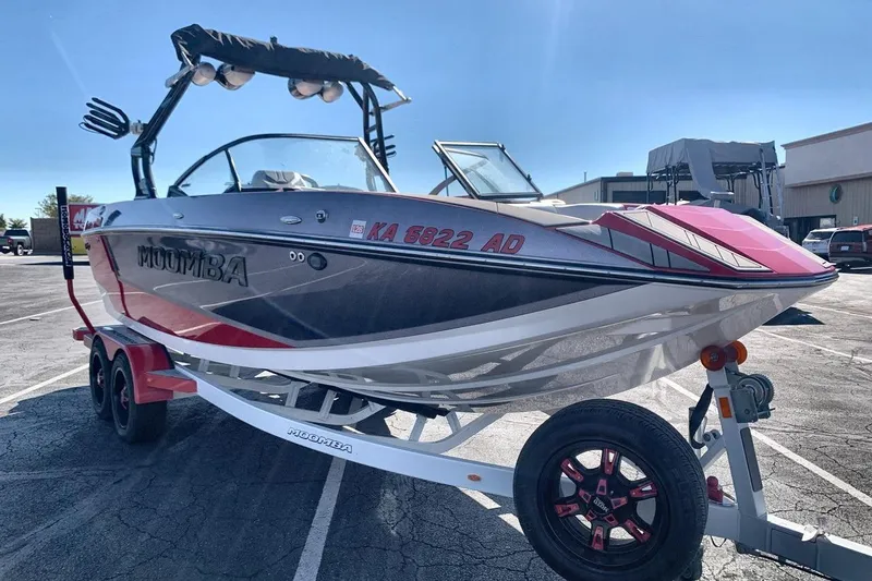 Slide: The Image of 2023 Moomba Mojo boat on trailer, parked outdoors, featuring sleek design and vibrant colors. - 7