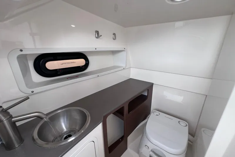 Slide: The Image of 2020 Sea Ray SDX 270 Outboard boat interior with sink, toilet, and storage. - 35