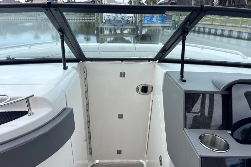 Slide: The Image of 2020 Sea Ray SDX 270 Outboard boat interior with open windshield and cup holder. - 36