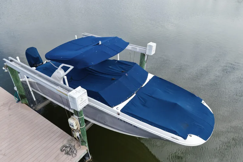 Slide: The Image of 2020 Sea Ray SDX 270 Outboard boat with blue covers docked on water. - 4