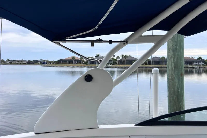 Slide: The Image of 2020 Sea Ray SDX 270 Outboard boat with blue canopy on calm water. - 41