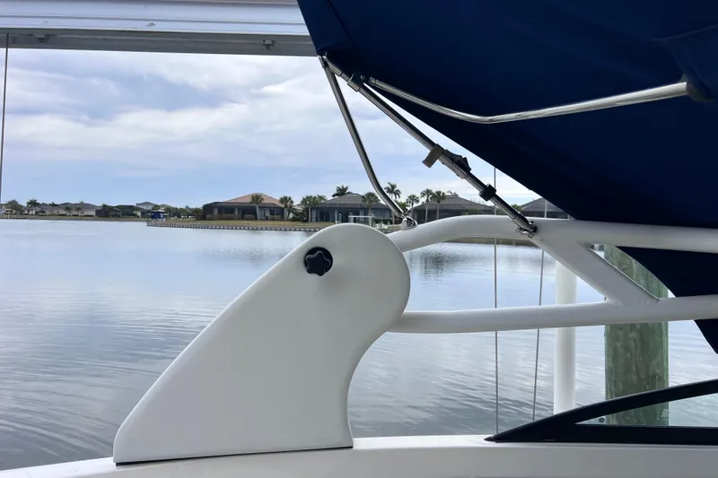 Slide: The Image of 2020 Sea Ray SDX 270 Outboard boat with blue canopy on a calm lake. - 42