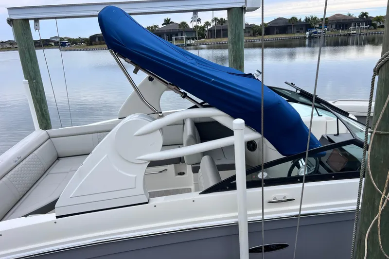Slide: The Image of 2020 Sea Ray SDX 270 Outboard boat docked, featuring a blue canopy and spacious seating. - 43