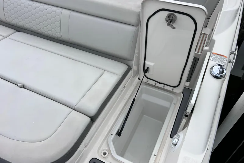 Slide: The Image of 2020 Sea Ray SDX 270 Outboard boat with open storage compartment and cushioned seating. - 49