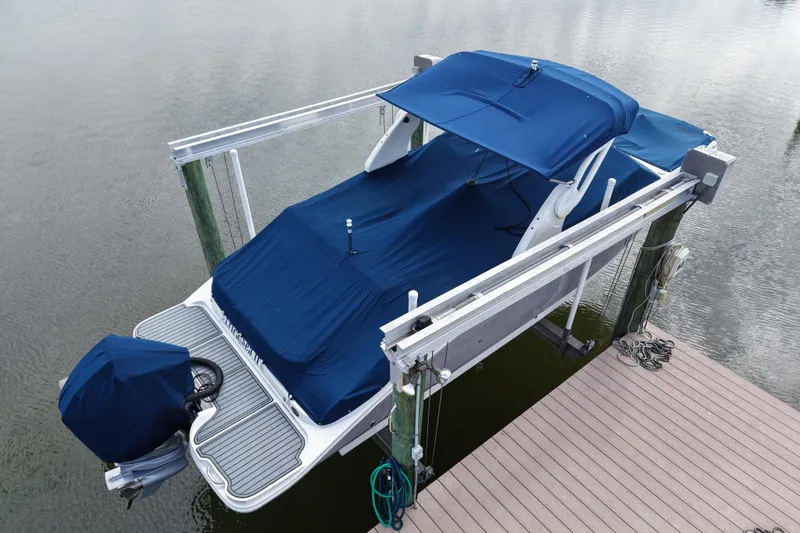 Slide: The Image of 2020 Sea Ray SDX 270 Outboard boat covered and docked on a lift. - 5