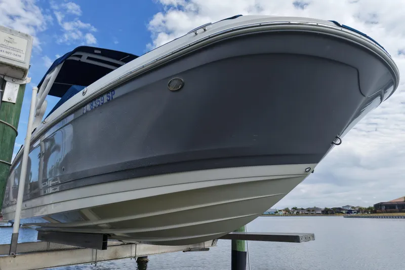 Slide: The Image of 2020 Sea Ray SDX 270 Outboard boat on lift by waterfront, under cloudy sky. - 9