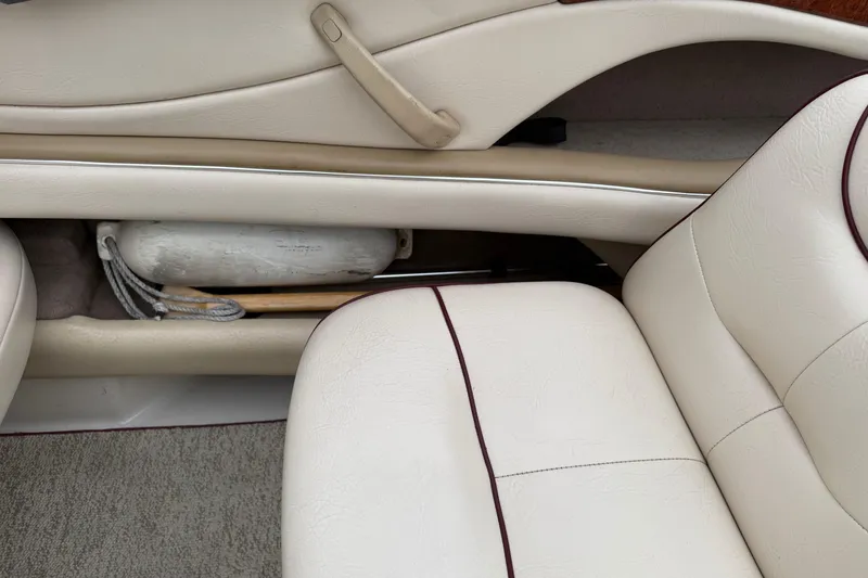 Slide: The Image of Interior of a 2000 Sea Ray 210 Bow Rider with white leather seats and storage compartment. - 11