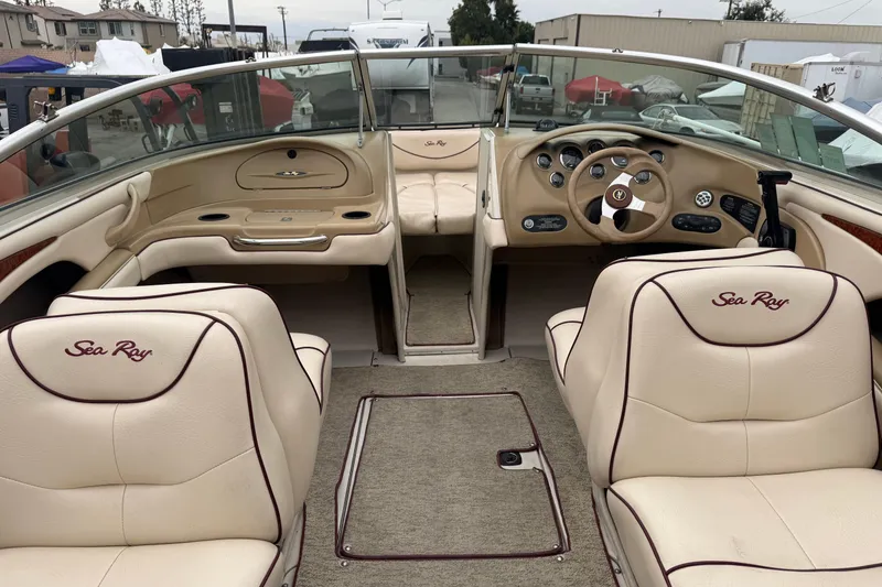 Slide: The Image of Interior of a 2000 Sea Ray 210 Bow Rider boat with beige seating and dashboard. - 13