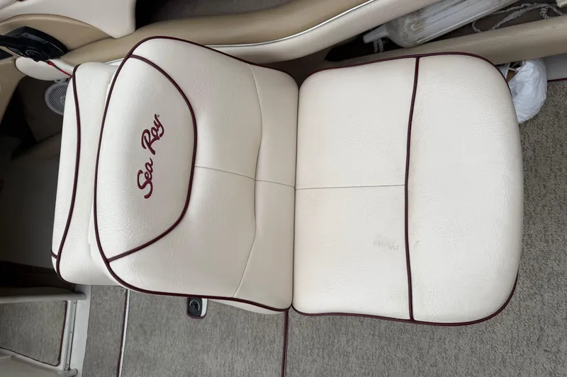 Slide: The Image of Sea Ray 210 Bow Rider 2000 boat seat with white upholstery and maroon trim. - 17