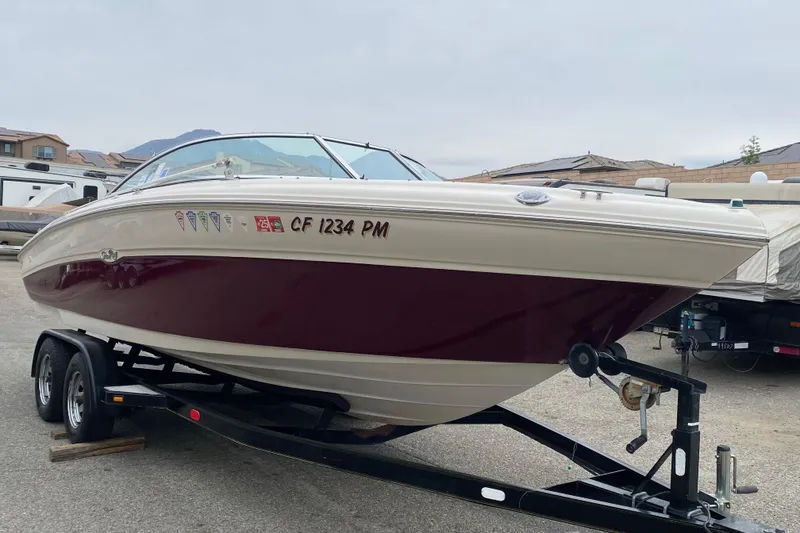Slide: The Image of 2000 Sea Ray 210 Bow Rider boat on trailer, parked outdoors. - 4