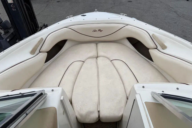 Slide: The Image of 2000 Sea Ray 210 Bow Rider boat interior with white cushioned seating. - 9
