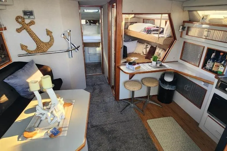 Slide: The Image of Interior of 1988 Sea Ray 390 Express Cruiser with cozy seating and nautical decor. - 17