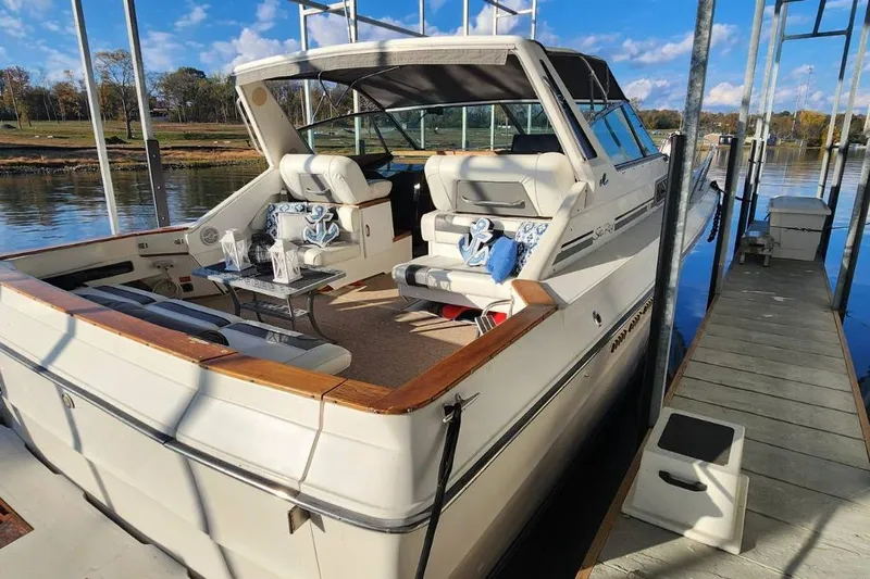 Slide: The Image of 1988 Sea Ray 390 Express Cruiser docked, featuring spacious seating and elegant design. - 2