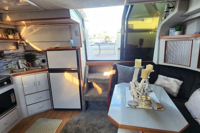 Slide: The Image of Interior of 1988 Sea Ray 390 Express Cruiser with kitchen and seating area. - 20