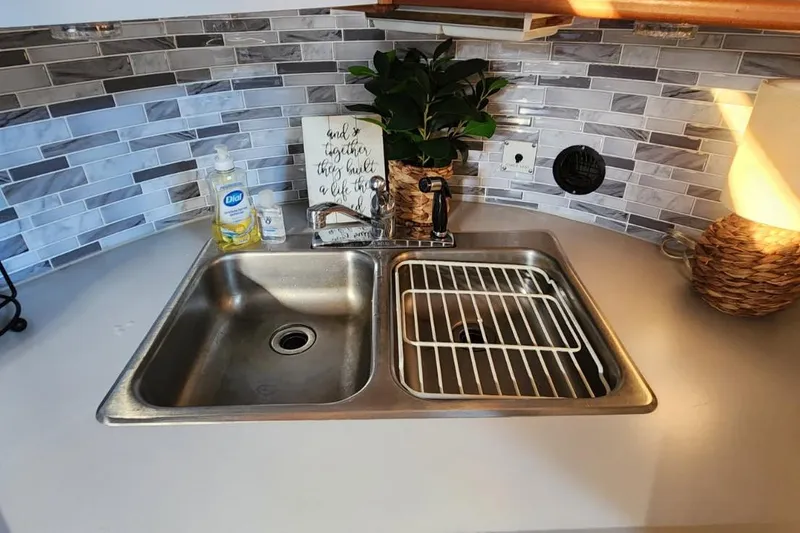 Slide: The Image of Stainless steel sink in 1988 Sea Ray 390 Express Cruiser kitchen with modern backsplash. - 21