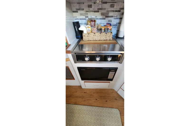 Slide: The Image of 1988 Sea Ray 390 Express Cruiser kitchen with stove, oven, and backsplash. - 22