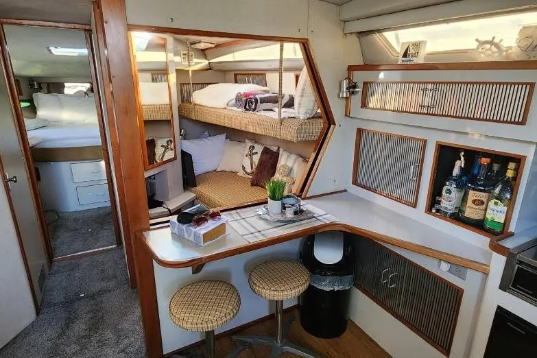 Slide: The Image of Interior of 1988 Sea Ray 390 Express Cruiser with cozy seating and bar area. - 24