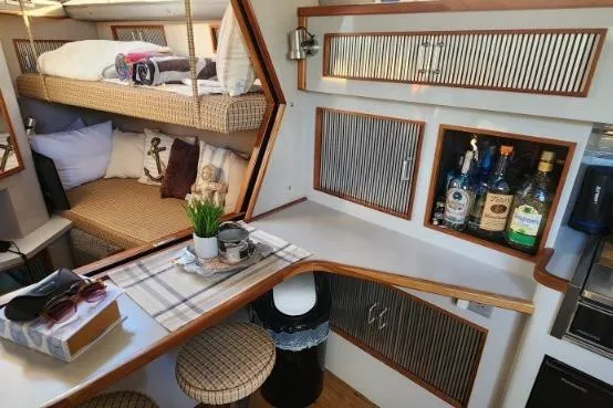 Slide: The Image of Interior of 1988 Sea Ray 390 Express Cruiser with cozy bunks and bar area. - 25