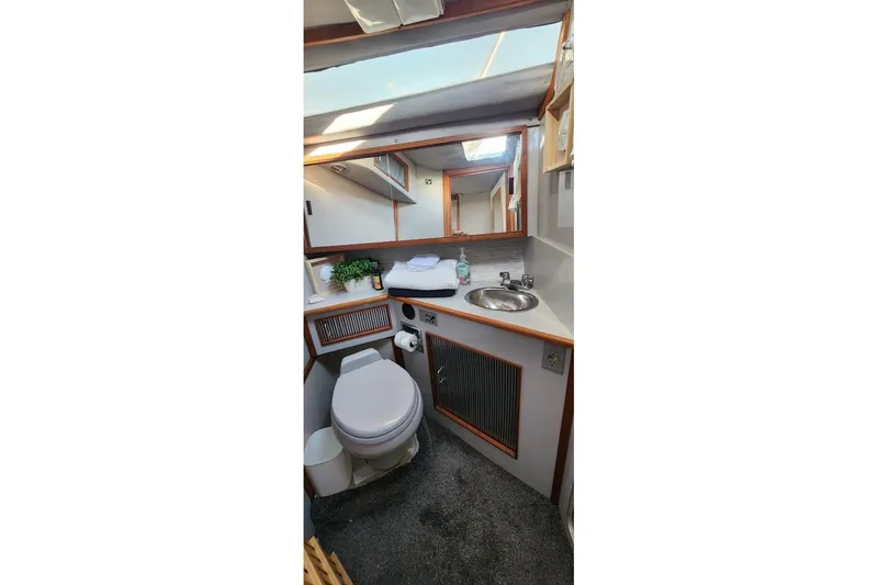 Slide: The Image of 1988 Sea Ray 390 Express Cruiser bathroom with sink, toilet, and mirror. - 33