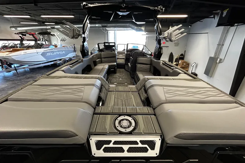 Slide: The Image of 2025 Supra SE boat interior with luxurious seating and modern design in showroom. - 4