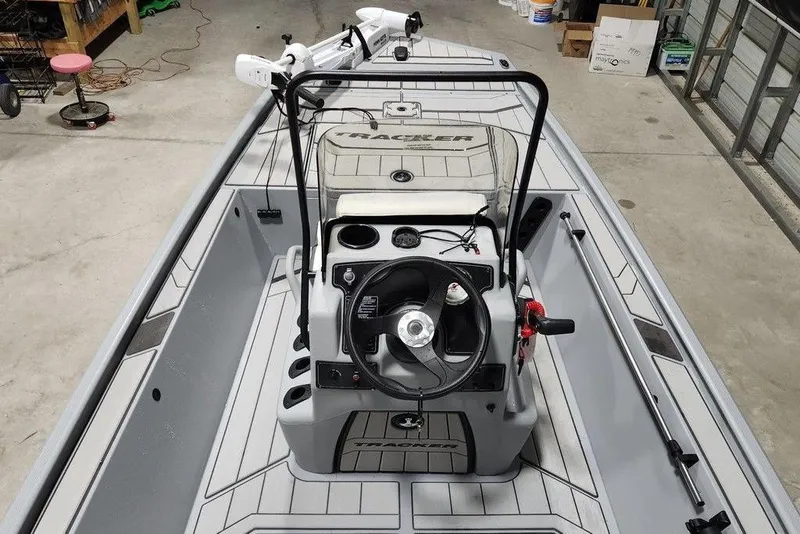 Slide: The Image of 2026 Tracker Bass Tracker Classic CC boat interior with steering console in a garage setting. - 5