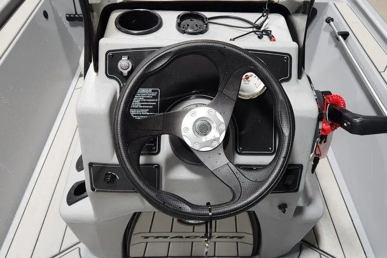 Slide: The Image of 2026 Tracker Bass Tracker Classic CC boat steering console with controls and cup holder. - 7