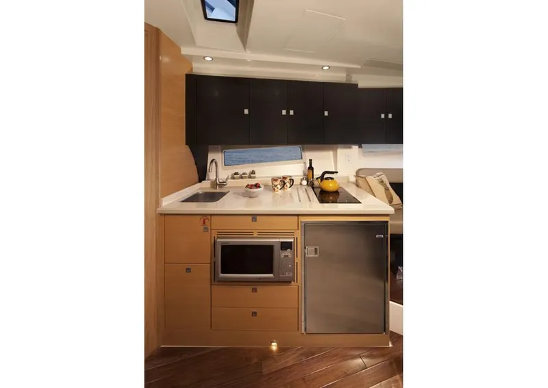 Slide: The Image of 2013 Pursuit SC 365i Sport Coupe interior with stainless steel fridge and cup holders. - 13