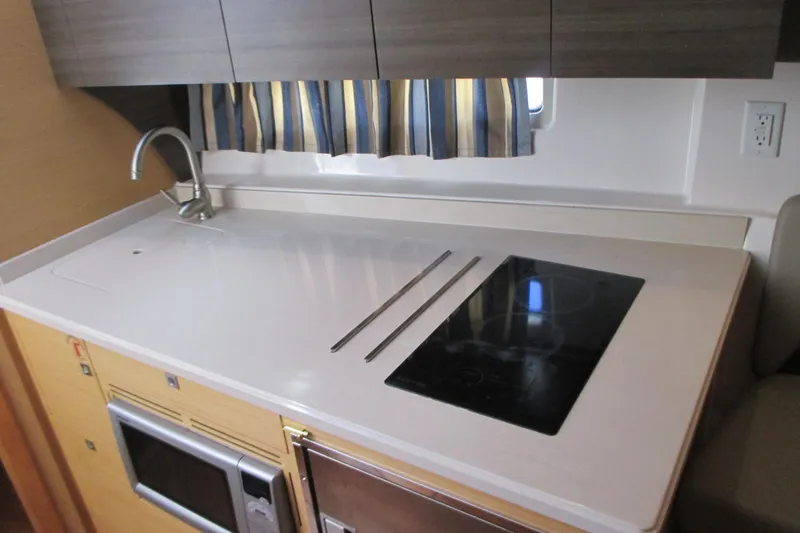 Slide: The Image of 2013 Pursuit SC 365i Sport Coupe kitchen with sink, stovetop, and microwave. - 28