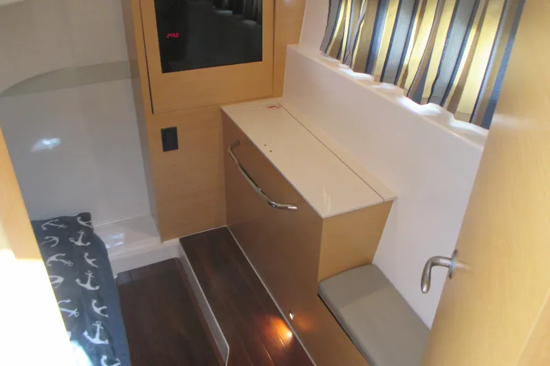 Slide: The Image of 2013 Pursuit SC 365i Sport Coupe interior with wood accents and nautical-themed bedding. - 32