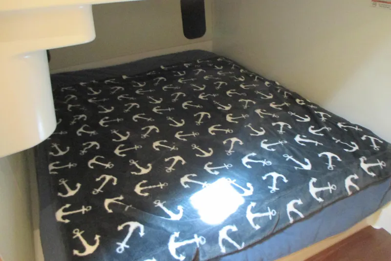 Slide: The Image of Cozy cabin bed with anchor-patterned blanket in 2013 Pursuit SC 365i Sport Coupe. - 33